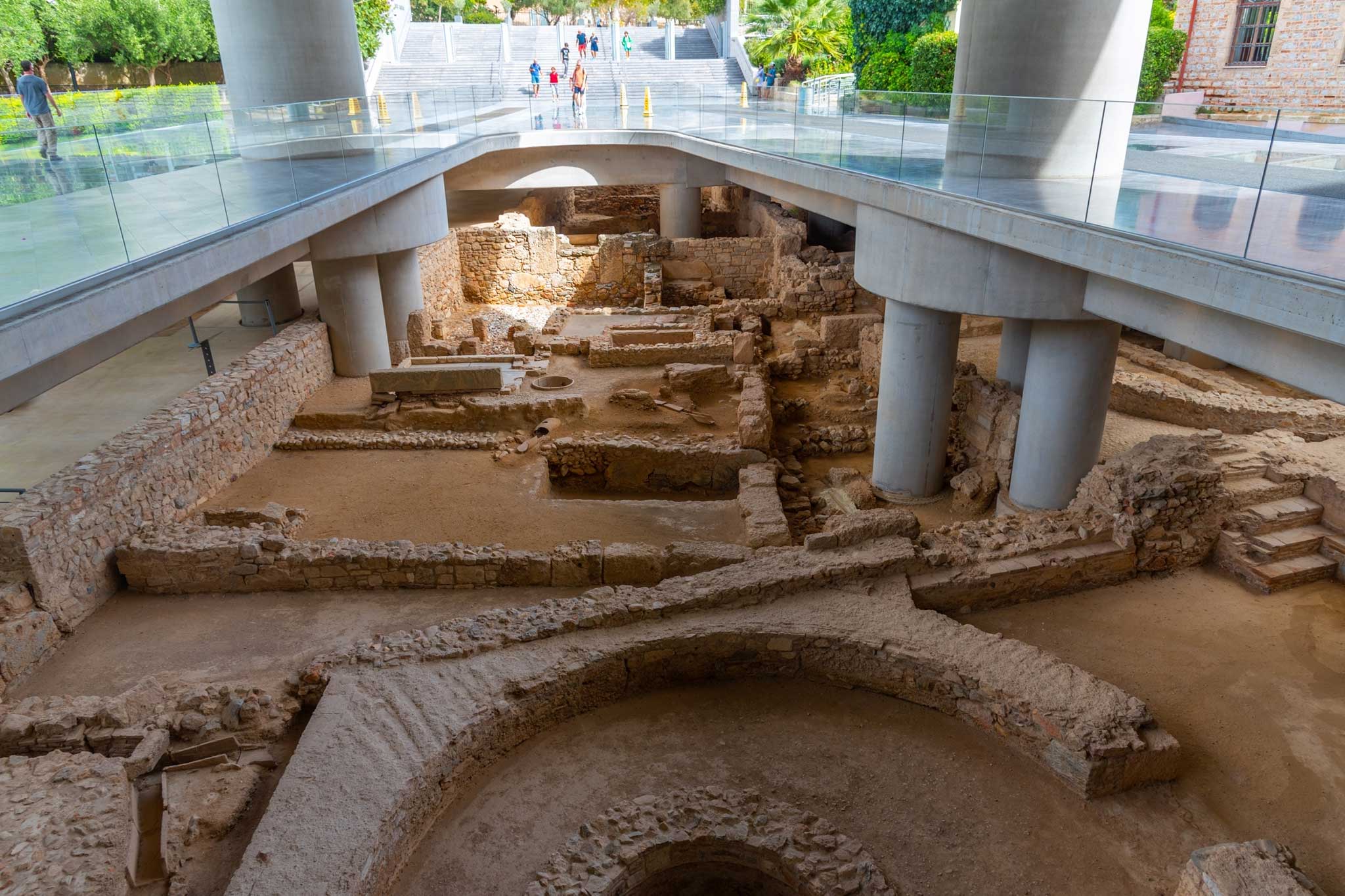Ancient foundations and structures under the Acropolis Museum, showcasing ancient excavation sites through transparent floors.