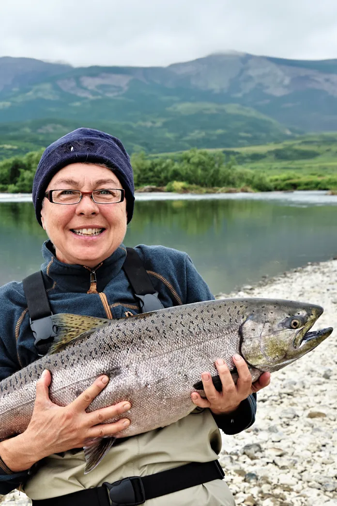 Woman holding fresh-caught salmon